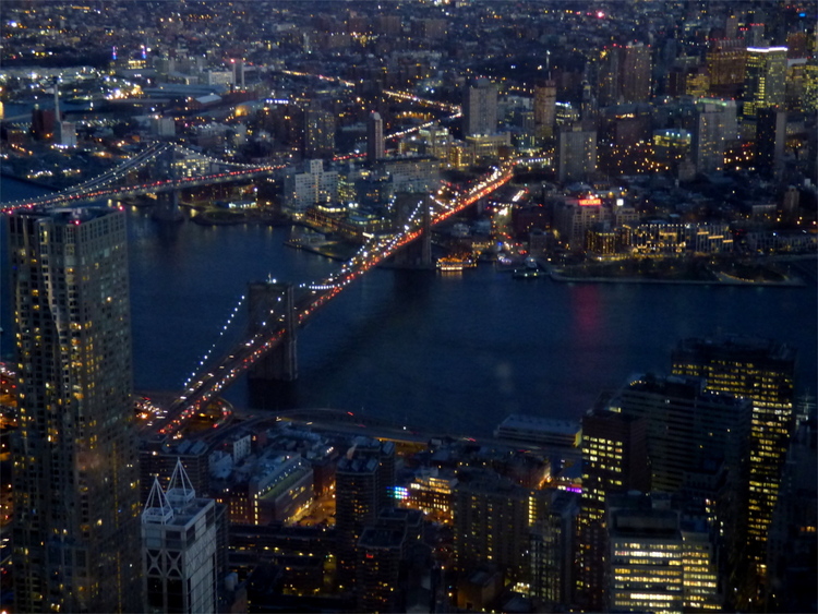 View of a lit-up bridge and the surrounding buildings at night