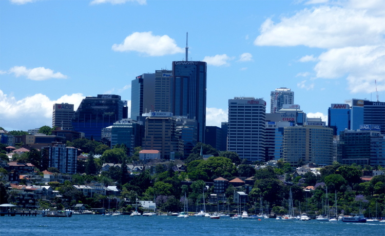 View of a city with some blue-ish high-rise buildings on a waterfront