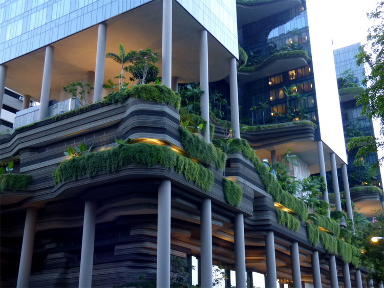 Futuristic architecture of a hotel building with large planted open spaces supported by columns included in it