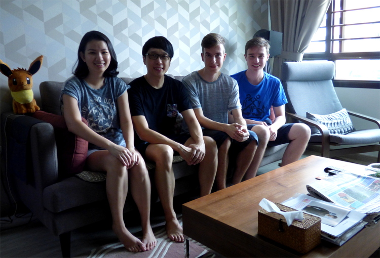Group picture of Stacy, Davon, Nils and Jan sitting on a couch in a living room with a Pokemon plush toy next to them