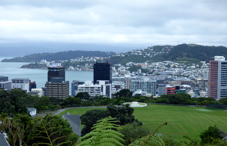 Panorama of a small city stretching out from beyond a large area of grass