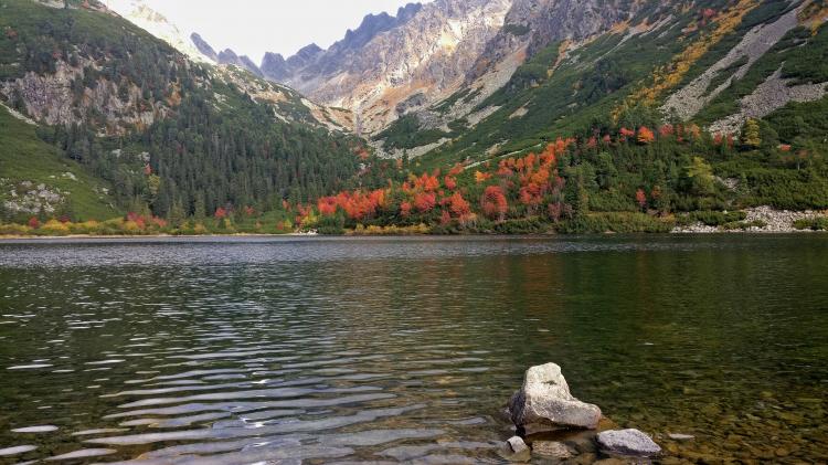 View of a mountain lake with colorful autumn trees around the shoreline