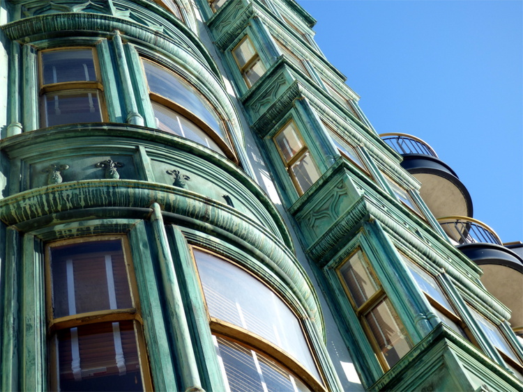 Windows and alcoves on a green oxidized copper facade 