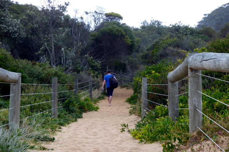 Jan walking on a sandy path into some greenery