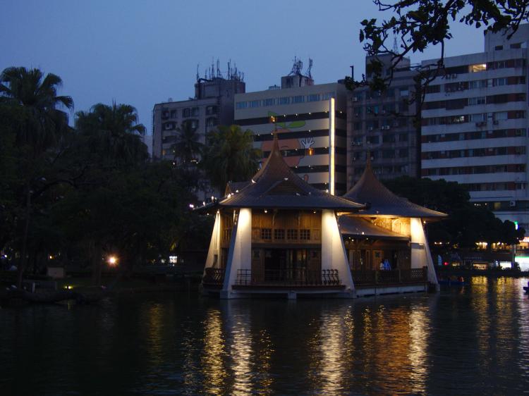 A small pavilion on a lake in a public park at night