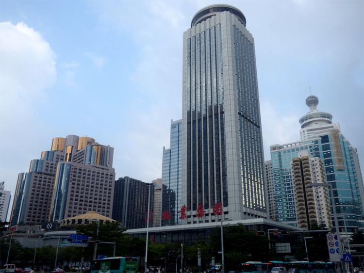 Modern, glass-clad high-rise buildings on a busy street intersection